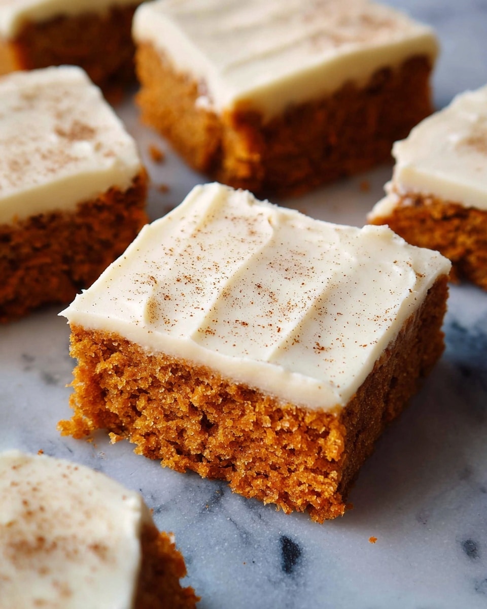 The image shows several square pieces of moist carrot cake arranged on a white marbled surface. Each piece has two distinct layers: the bottom layer is a textured, golden-brown carrot cake with visible crumbs, and the top layer is a smooth, thick, creamy white frosting sprinkled with light brown cinnamon or spice powder. The frosting covers the cake evenly with a few gentle ridges and swirls, giving a homemade appearance. The cake pieces are close to each other but not touching, and the lighting highlights the moistness and softness of the cake layer. photo taken with an iphone --ar 4:5 --v 7