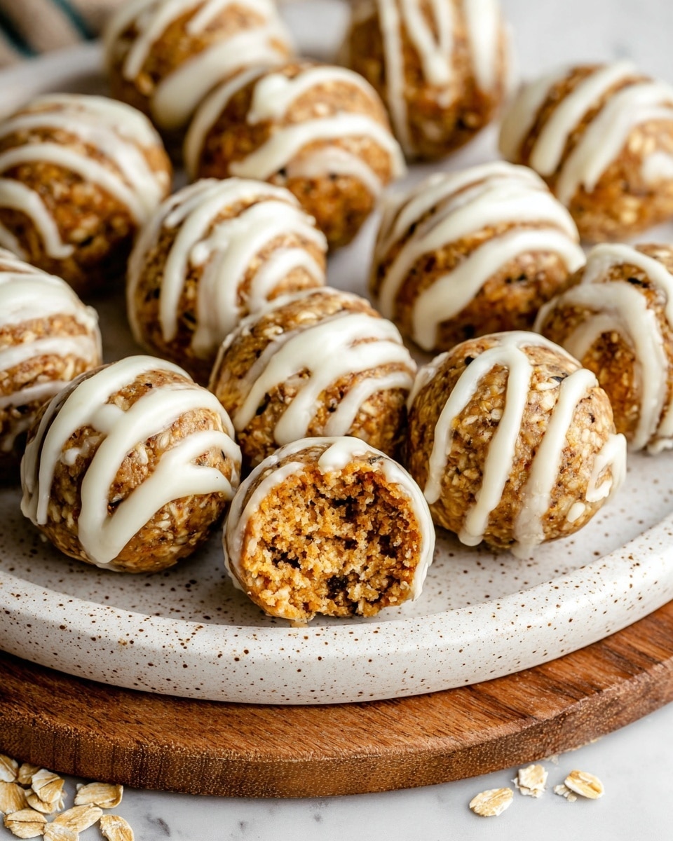 The image shows round oat energy balls, arranged closely on a white speckled plate. Each ball is light brown with visible oats and seeds throughout, and they are drizzled with thin white icing on top. One ball in the front is cut in half, showing a dense, slightly crumbly inside with bits of oats and seeds. The plate sits on a wooden board with a few loose oat flakes scattered around. The background is a white marbled texture. photo taken with an iphone --ar 4:5 --v 7