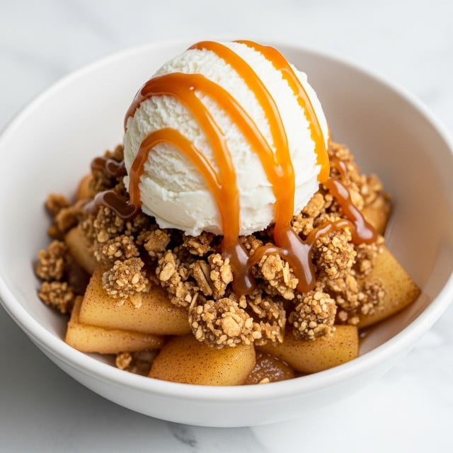 A white bowl holds a warm dessert with three visible layers: the bottom layer looks like soft, cooked apple slices coated in a light cinnamon sauce; above that is a crunchy, golden brown oat crumble with a rough texture; on top sits a smooth, round scoop of white vanilla ice cream, drizzled with glossy caramel sauce flowing down the sides. The bowl rests on a surface with a white marbled texture. photo taken with an iphone --ar 4:5 --v 7