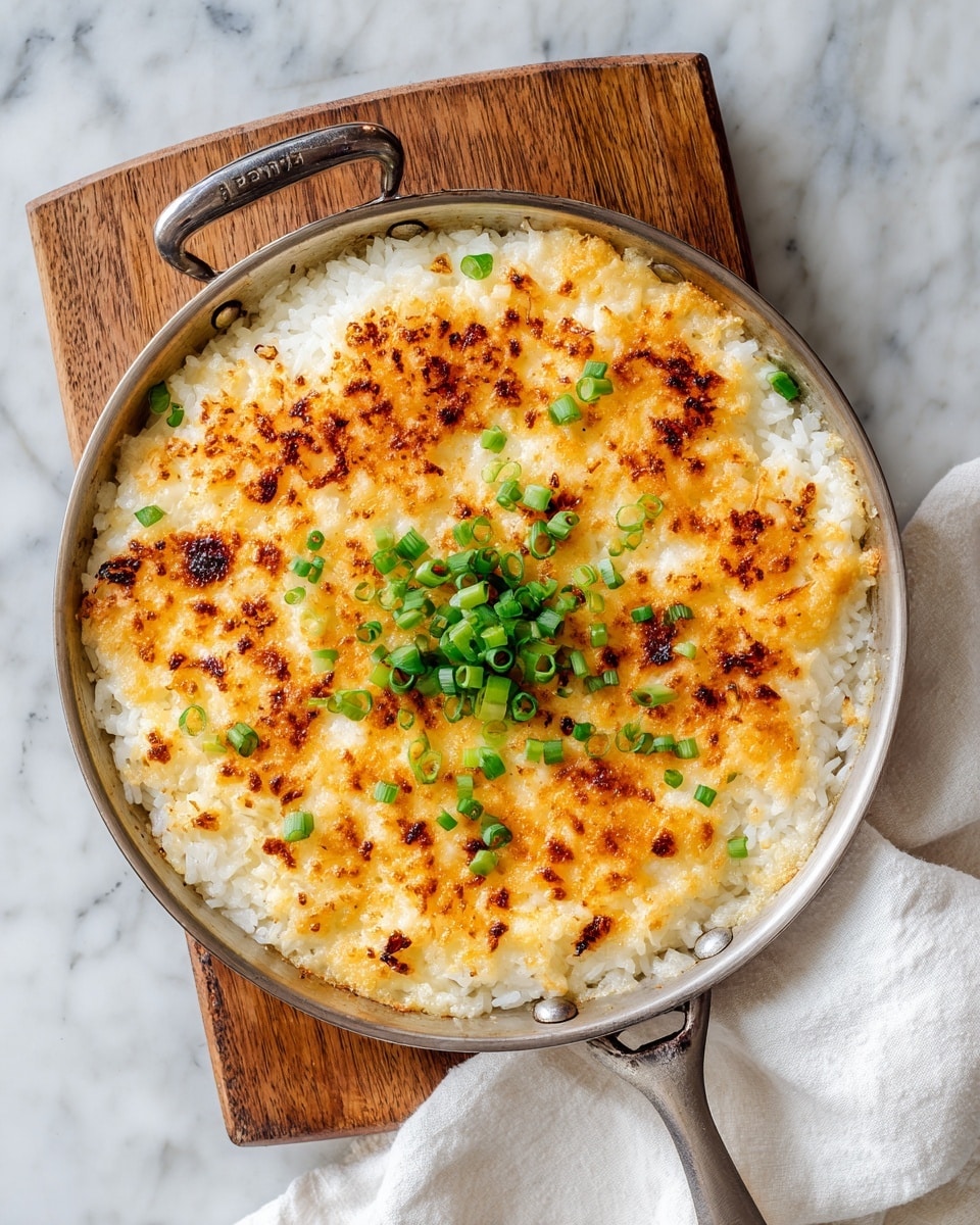 A close-up top view of a single-layered golden-brown crispy rice dish in a round black cast iron pan with a handle on the right, topped with a small mound of finely chopped bright green spring onions in the center, with some grains of rice lightly browned and crispy, all set on a white marbled texture surface with a light wood board partially visible underneath the pan. Photo taken with an iphone --ar 4:5 --v 7