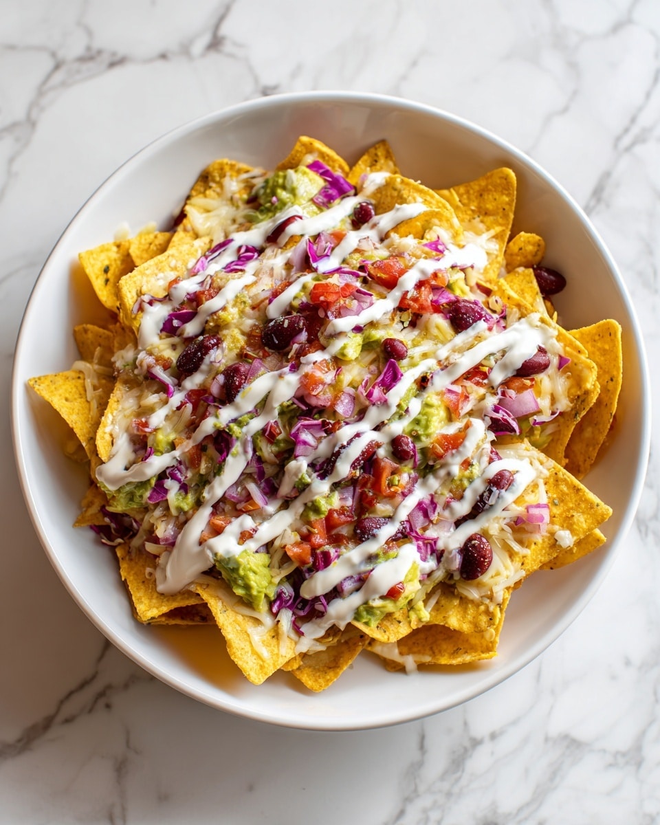 The dish is a bowl of nachos with a white marbled surface underneath. The nachos form a base layer of golden yellow, crunchy triangular chips spread evenly. On top, layers of shredded white cheese melt in places, mixed with chunks of bright green avocado and pieces of purple cabbage. There are scattered black beans and bits of chopped chicken with a light brown color. The food looks fresh and colorful with a mix of textures from crispy chips to creamy and soft toppings. Photo taken with an iphone --ar 4:5 --v 7