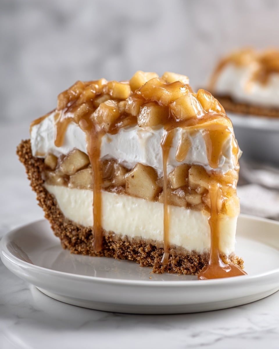 The image shows a slice of dessert on a white plate with a white marbled surface in the background. The dessert has four layers: the bottom crumbly light brown crust, a thick creamy white layer above it, next sits a layer of chopped apples mixed with a light brown sauce, and the top layer is fluffy whipped cream covered in glossy caramel sauce with bigger pieces of apple on top. The colors range from light brown, white, to darker caramel shades. The texture contrasts from crumbly crust to smooth cream and soft fruit. Photo taken with an iphone --ar 4:5 --v 7